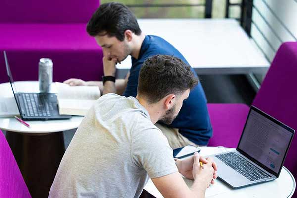 students at lap top computers in lunch room